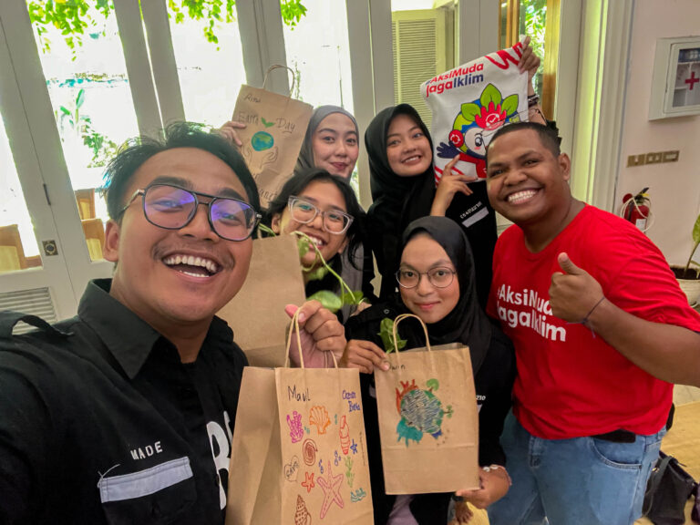 Peserta Workshop Kokedama HIMITEKA memegang hasil karya lukis di Hari Bumi 2025 bersama Penjaga Laut Indonesia