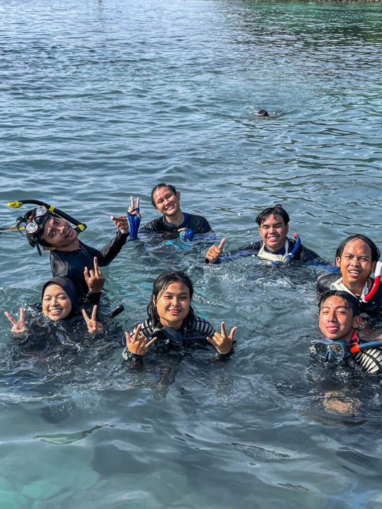 Kelompok mahasiswa HIMITEKA berpose bersama di laut usai sesi penyelaman.